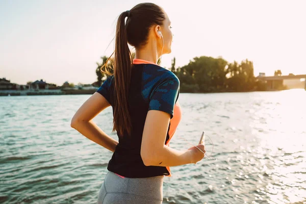 Runner onun elinde bir akıllı telefon ile gün batımında çalışır ve müzik dinliyor