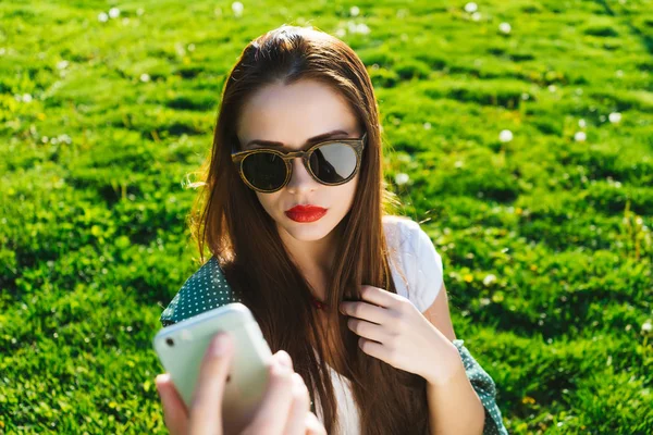 Mujer haciendo selfie en el teléfono inteligente blanco fuera, copyspace — Foto de Stock