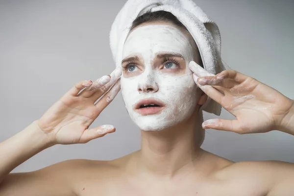 Mujer con cosméticos blancos mack en la cara, exfoliante, hidratante —  Fotos de Stock