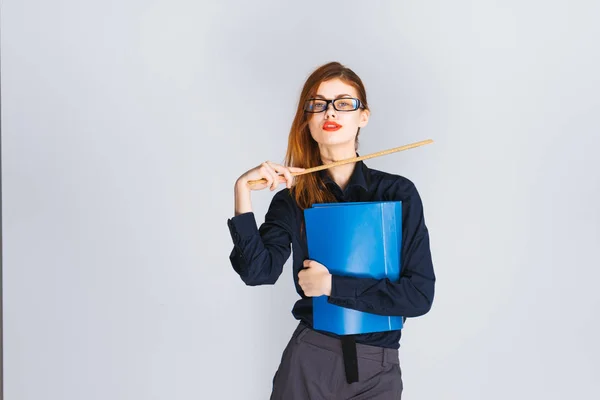 Junge Lehrerin mit Brille hält eine Feile am Kinn mit einem Lineal — Stockfoto