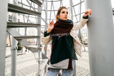 bir eşarp ile düşünceli bir kız Kulesi tasarım ilgi ile görünüyor.