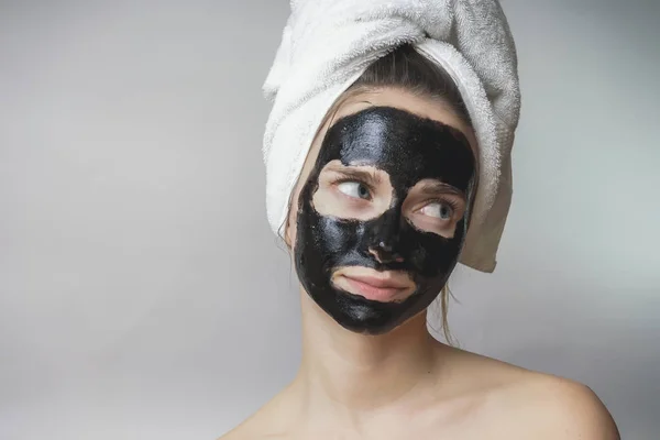 Fekete maszk nő arcán, mosolyogva, bőrápoló, tisztító pórusok, akne ellen — Stock Fotó