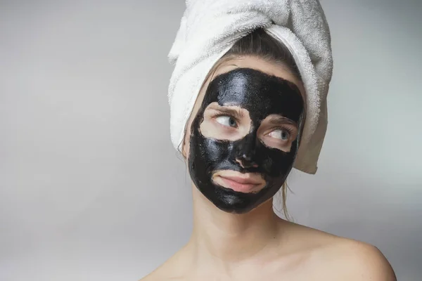 Máscara negra en la cara de la mujer, sonriente, cuidado de la piel, poro de limpieza, contra el acné — Foto de Stock