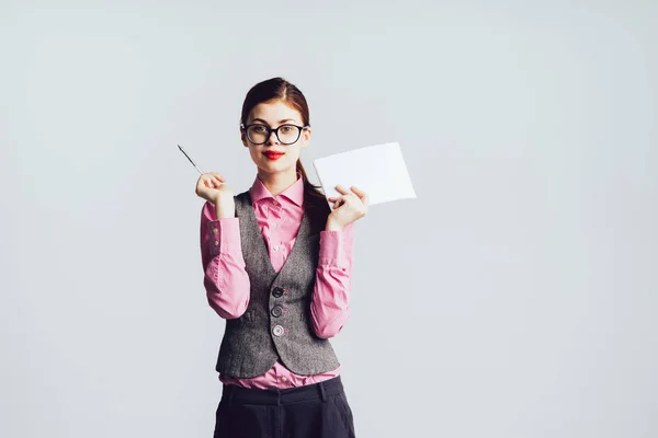 Niedliches Mädchen im Anzug und rosa Hemd mit Stift und Papier — Stockfoto