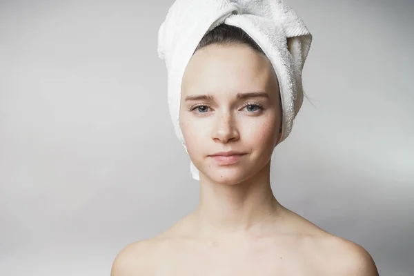 Mulher bonita com toalha na cabeça olhando para a câmera, sorriso — Fotografia de Stock