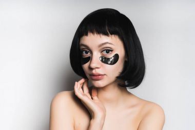 Gözlerinin altındaki maskesi olan bir kadın yüzü, bir genç bir kısa saç kesimi ile dokunur