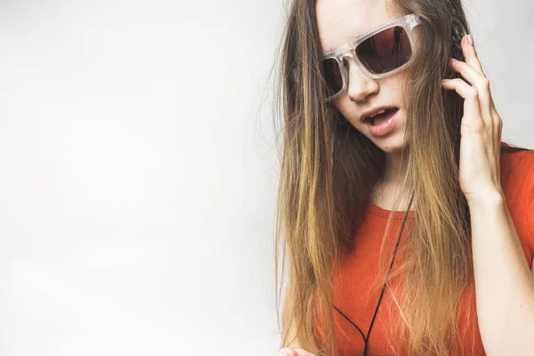 Happy young woman listening, long hair, cool sunglasses. Woman in headphones and glasses — Stock Photo, Image