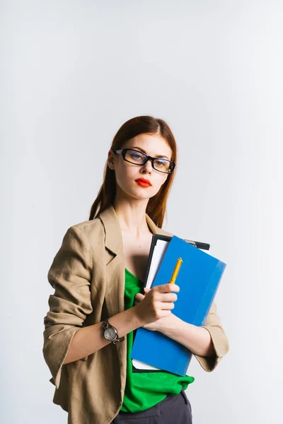 Helles Mädchen mit Brille und rotem Lippenstift hält Ordner in den Händen und schaut genau hin — Stockfoto