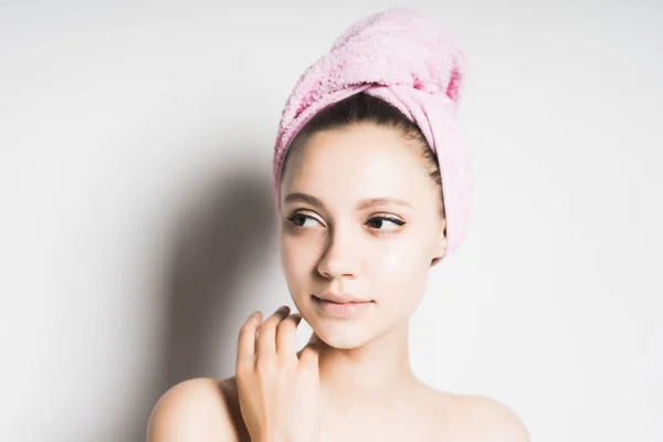 Girl after shower with a towel on her head looking to the side, isolated — Stock Photo, Image