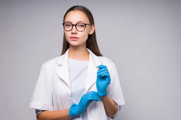 Försiktig uppmärksam praktikant läkare i medicinsk klänning och handskar — Stockfoto
