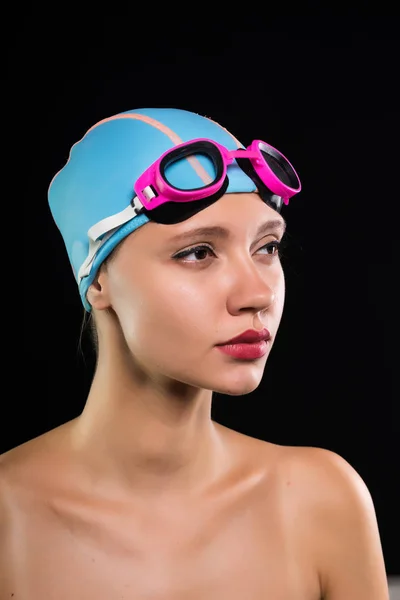 Uma garota séria em uma touca de natação e óculos está se preparando para nadar, piscina — Fotografia de Stock