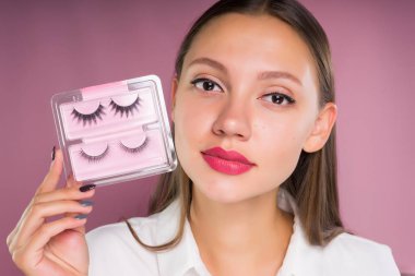 güzel kız güzel dudaklı sahte kirpik onun elinde tutar.