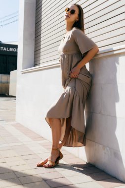 Kız güzel bej uzun elbise bir şehir sokak poz