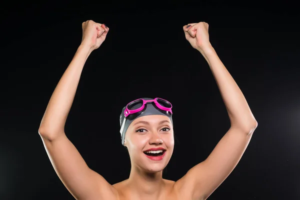 Смеющаяся девушка в плавательной шапке и очках собирается пойти к бассейну — стоковое фото