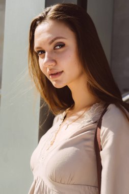 Elbise güzel kız güzel bir gülümseme ve gözlük ile hassas bir bej