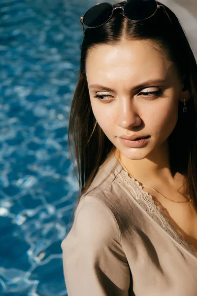 A menina olha atenciosamente de lado, junto à piscina — Fotografia de Stock