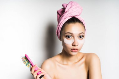 sürpriz bir ifade ile başında bir havlu ile genç kız bir tarak onun elinde tutar.