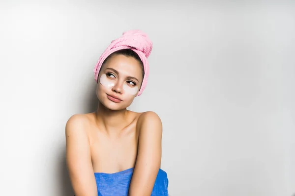 Menina com uma toalha na cabeça olha para longe pensativo — Fotografia de Stock