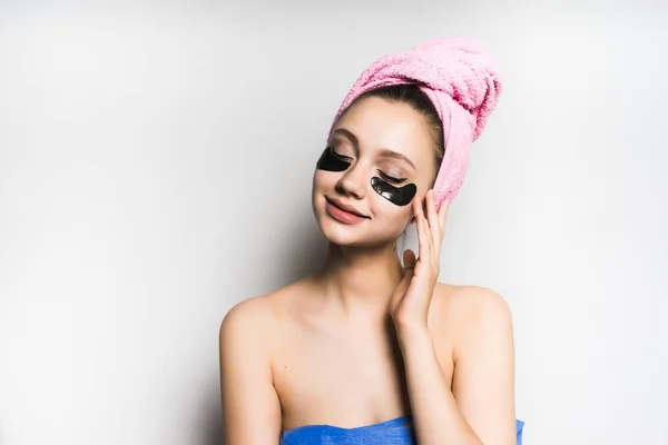 Dívka s ručníkem na hlavě staví černou masku na tváři — Stock fotografie