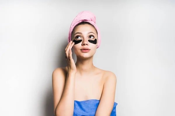 Menina com uma toalha na cabeça coloca uma máscara em seu rosto — Fotografia de Stock