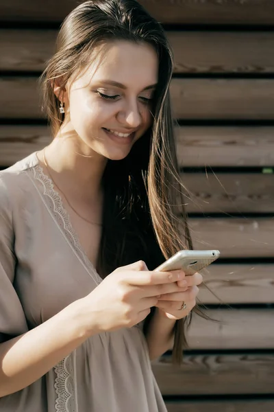 Girl smiling by correspondence with someone on the phone — Stock Photo, Image