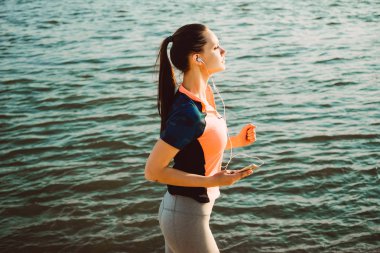 kulaklık kız nehirde çalıştırmak bir akşam gerçekleştirir