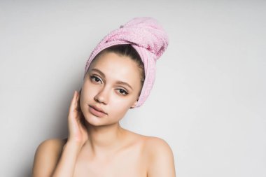 onun başının etrafında bağlı bir havlu ile bir kız makyaj yaparken koyar