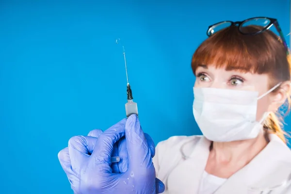 Una doctora extrae aire de una jeringa mientras se prepara para inyectarse — Foto de Stock