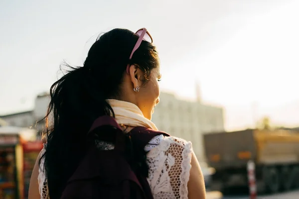 Κορίτσι ταξιδιώτης με ένα σακίδιο, το περπάτημα γύρω από την πόλη στο ηλιοβασίλεμα — Φωτογραφία Αρχείου