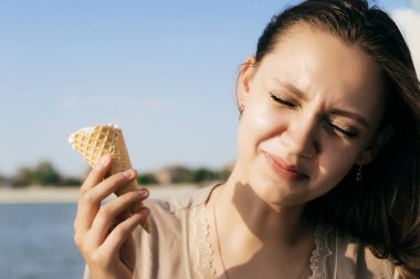 bir kız bir dondurma günbatımında tutan gülüyor