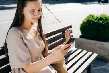 Kız elini saçları ile oynama ve gülümseyen bir telefon ile