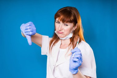 kadın doktor gösterir başparmak aşağı tıbbi maskesi