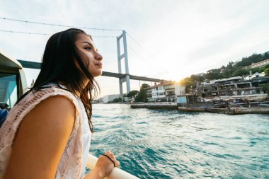 Sürpriz, tekne turu boğaz, modern köprü şehirde meraklı genç kız bakar