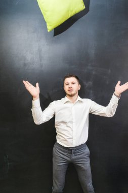 genç bir adam ve yeşil bir yastığı atar kameraya benziyor