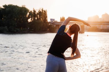 kız koşu önce egzersizleri yapıyor gün batımında
