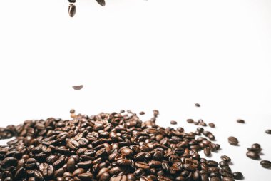 Kızarmış bir beyaz arka plan üzerinde düşen kahve taneleri