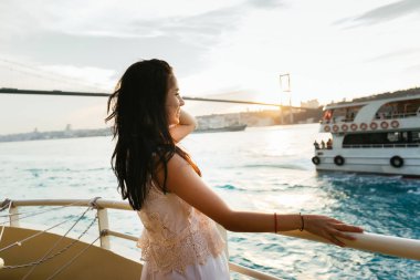 Genç kız seyahat sırasında bir yat gezisi, sunset ve yelken feribot ile bakar rahatlatır
