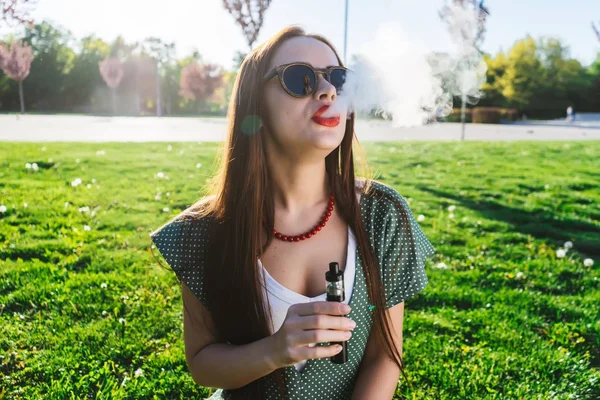 Felice moda sorridente Donna in occhiali da sole fumo vaporizzatore sulla strada, fumo — Foto Stock