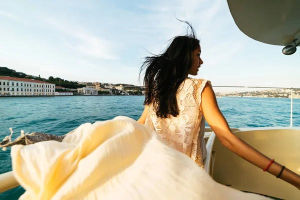 Bir kız bir tekne, bir teknede günbatımı şehir manzarasına bakar