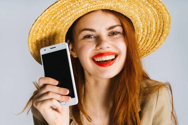 güzel kızla parlak kırmızı dudaklar telefon el ve gülümsüyor tutar