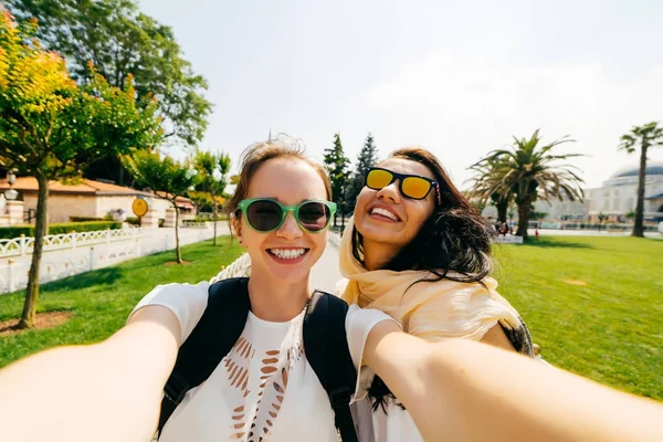 Beyaz diş hekimi gülümsüyor ile iki gülümseyen kız arkadaşım selfie yapmak. Farklı uluslardan, dostluk insanlar