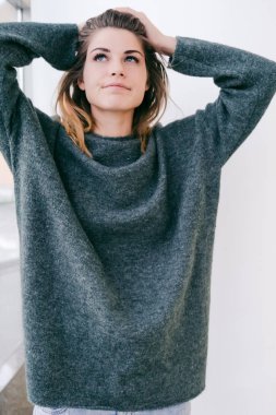 büyük bir karanlık kazaklı gülümseyen kız baktı