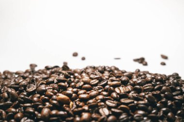 tahıl düşen beyaz bir arka plan üzerinde kahverengi kahve çekirdekleri yakın çekim