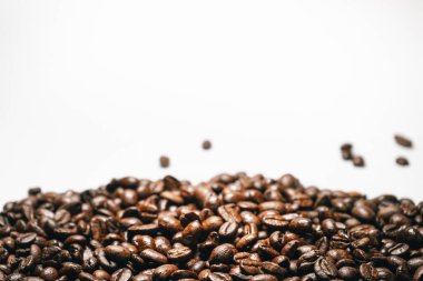 tahıl düşen beyaz bir arka plan üzerinde kahverengi kahve çekirdekleri yakın çekim