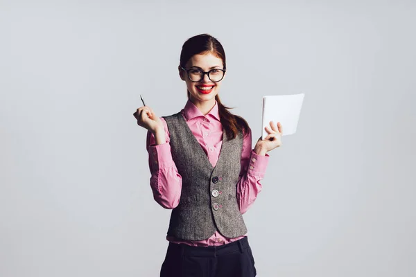 Ein Mädchen mit Brille hält einen Stift und Blatt Papier in der Hand — Stockfoto
