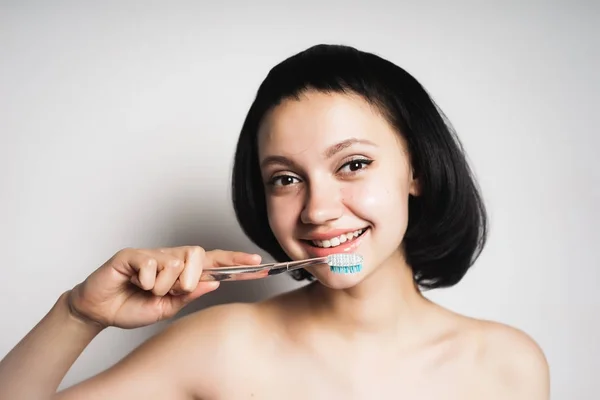 Mignonne fille souriante brossera ses dents brosse bleue — Photo