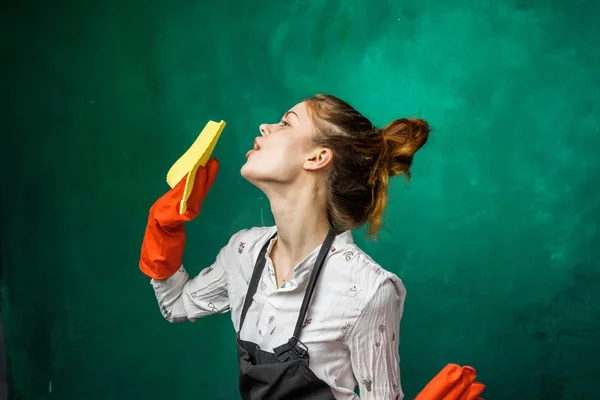 Смішна мила дівчина робить прибирання в помаранчевих рукавичках — стокове фото