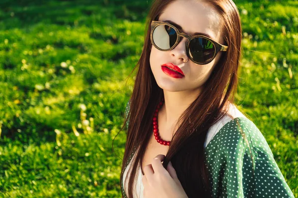 Женщина с красными губами в темных солнцезащитных очках, копирайс, трава летний фон — стоковое фото