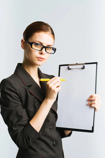Girl in glasses and in suit shows pencil something on paper A4 Stock Image