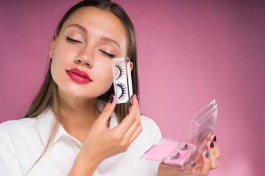 onun elleri yanlış eyelashes içinde tutan Kapalı gözlerle sevimli kız